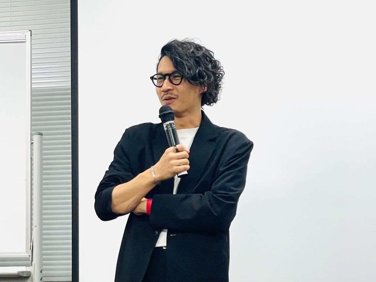 マイクを持ち、腕を組んで話す高橋直寛